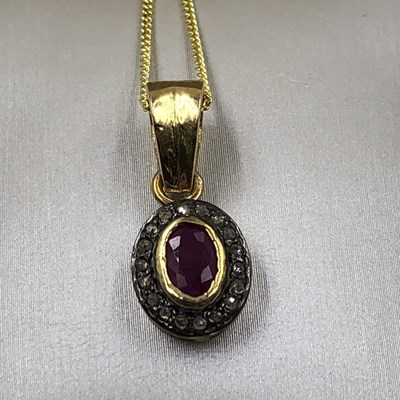 Lot 1018 - An oval ruby and round brilliant cut diamond...