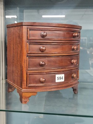 Lot 594 - A miniature mahogany bow front chest of four...