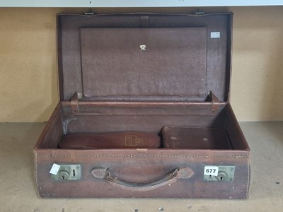Lot 677 - A leather suitcase containing a vanity set and...