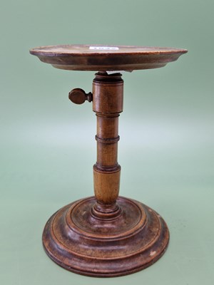 Lot 1542 - A walnut candlestand, the dished top...