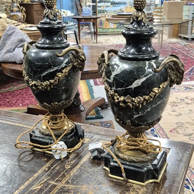 Lot 1588 - A pair of mottled black stone baluster table...