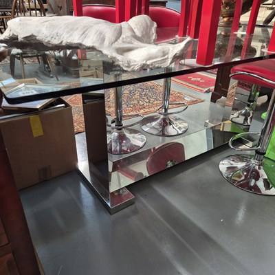 Lot 203 - A chrome based designer glass top dining table....