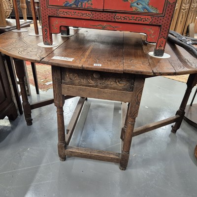 Lot 283 - A vintage oak drop leaf dining table with...