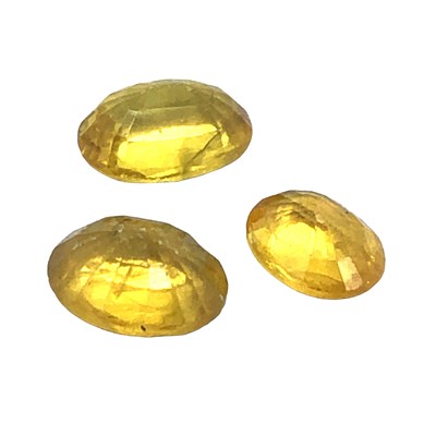 Lot 1078 - Three loose oval-cut yellow sapphires, gross...