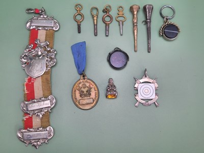 Lot 1096 - A collection of fobs, watch keys, a medallion...