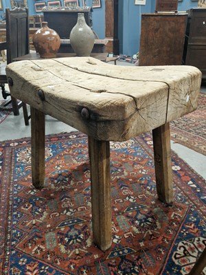 Lot 1318 - A plank top chopping block supported on legs...