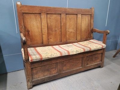 Lot 1314 - A 19th century oak settle, the four panel back...