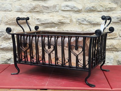 Lot 1254 - A two-handled wrought iron wood basket with a...