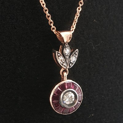 Lot 1034 - An 8ct rose gold target style pendant with...