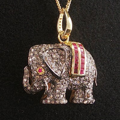 Lot 1047 - A silver gilt elephant pendant set with rubies...