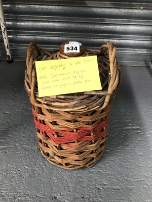 Lot 534 - A basket bound gallon flask of Naval rum said...