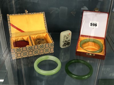 Lot 596 - Three Chinese green stone bangles, a...