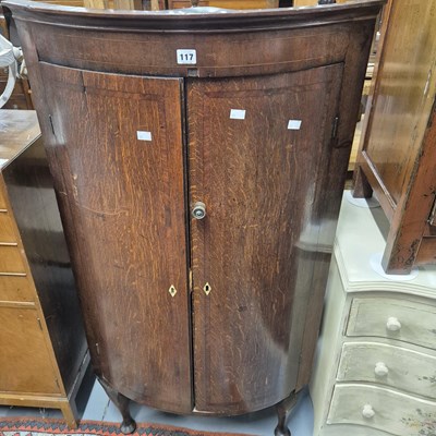 Lot 117 - A Georgian oak bow-front corner cabinet H...