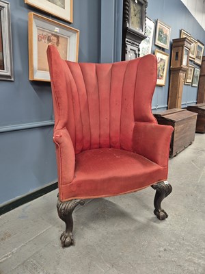 Lot 1149 - A wing arm chair with a rounded back, the...