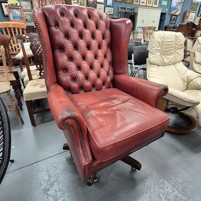 Lot 391 - A large wing back swivel armchair
