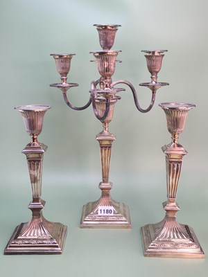 Lot 1180 - A pair of candlesticks en suite with a three...
