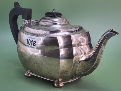 Lot 1018 - A silver tea pot with a black handle, Chester...