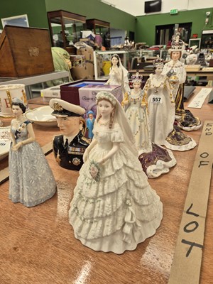 Lot 557 - Four porcelain figures of Queen Elizabeth II,...