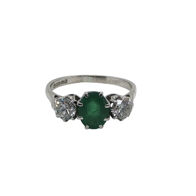 Lot 1114 - An 18ct white gold oval emerald and round...
