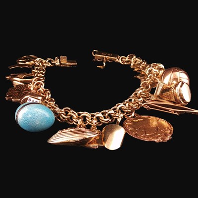 Lot 1156 - A vintage gold bracelet and charms. The...