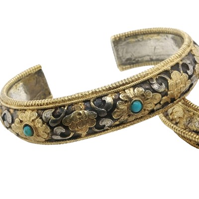 Lot 1159 - Two Himalayan parcel-gilt silver open-cuff...