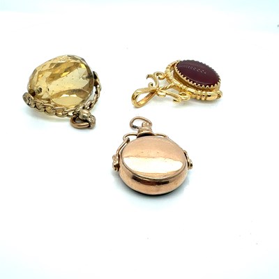 Lot 1168 - Three fob pendants, each mounted in 9ct gold;...