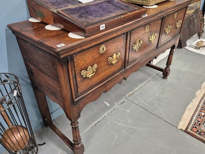 Lot 57 - A Georgian-style oak three-drawer dresser base...