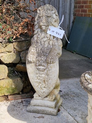 Lot 941 - Two stone lion figures holding shields. H 83 W...