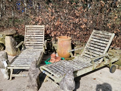 Lot 948 - A pair of garden teak reclining sun loungers....