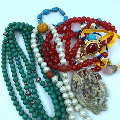 Lot 1186 - A collection of eastern beads and a carved...