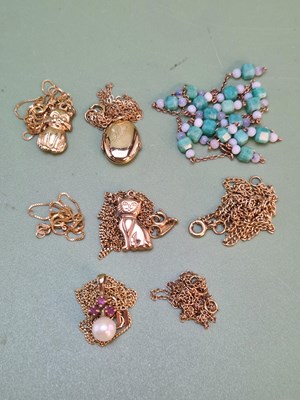 Lot 1200 - Four gold pendants with chains, a small...