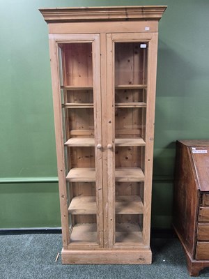 Lot 393A - A tall glazed pine display cabinet with seven...