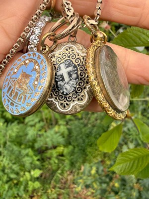 Lot 116 - Three lockets, each holding something...