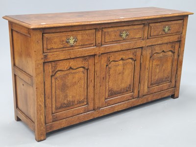 Lot 1098 - A 20th century oak dresser with three drawers...
