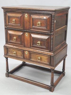 Lot 1099 - An 18th century oak chest on stand, the two...