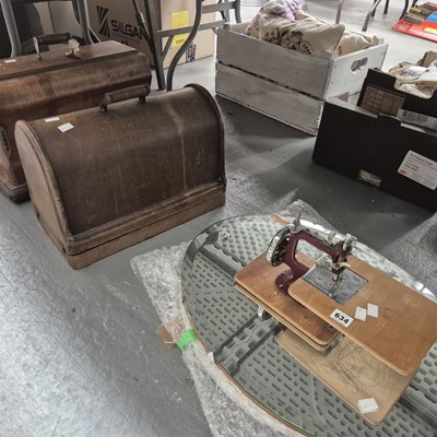 Lot 634 - Two cased sewing machines, another loose...