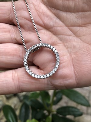 Lot 1125 - 9ct white gold circular diamond set pendant on...