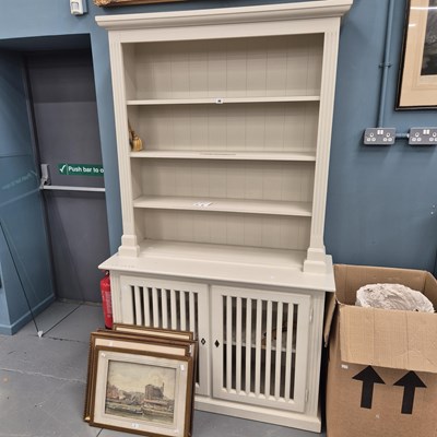 Lot 46 - A painted open bookcase with a cabinet base...