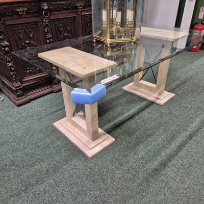 Lot 429 - A glass-topped dining table on marble supports...