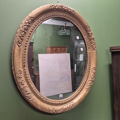Lot 442 - A large antique oval gilt framed wall mirror...