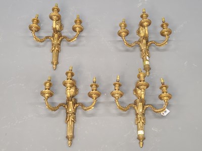 Lot 1381 - A set of four ormolu three branch wall lights,...