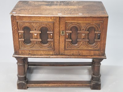 Lot 1415 - An 18th century oak side cupboard, the doors...