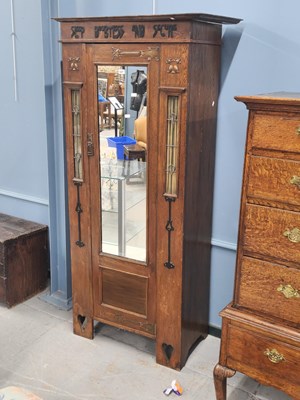 Lot 1427 - An Arts and Crafts oak wardrobe, the mirrored...