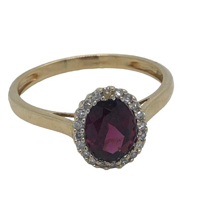 Lot 1178 - A 9ct hallmarked gold, gemset and diamond oval...