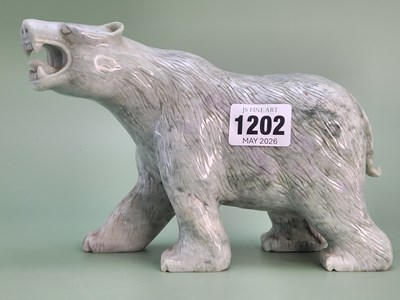 Lot 1202 - A mottled green stone carving of a growling...