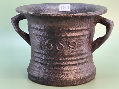 Lot 1211 - A cast iron two handled mortar dated 1699 on...