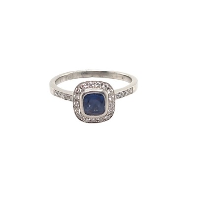 Lot 1035 - A sapphire and diamond cluster ring, centred...
