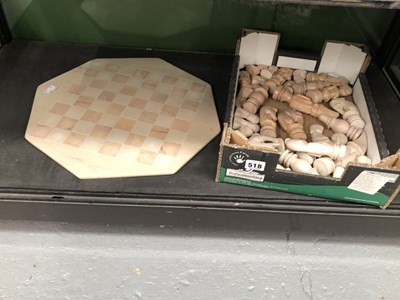 Lot 518 - A carved stone chess set and board
