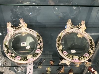 Lot 582 - A pair of oval bevelled wall mirrors with...