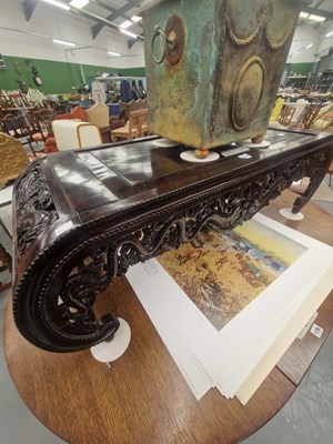 Lot 177 - An oriental coffee table carved with stylised...